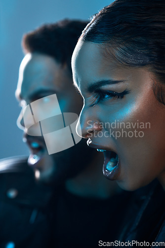 Image of Theyre serious about fashion. Conceptual shot of a stylish young man and woman posing in studio against a blue background.