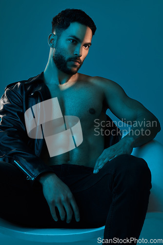 Image of A little leather for the ladies. Conceptual shot of a stylish young man posing in studio against a blue background.