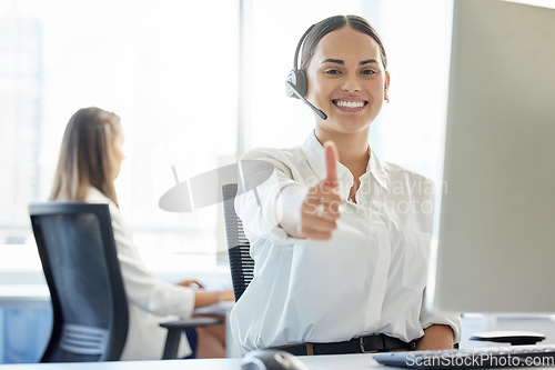 Image of Delivering exceptional service. a young woman showing thumbs up while working in a call center.