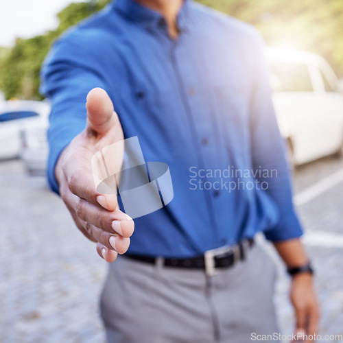 Image of Wlcome onboard. an unrecognizable businessman standing with his hand outstretched for a handshake outside.