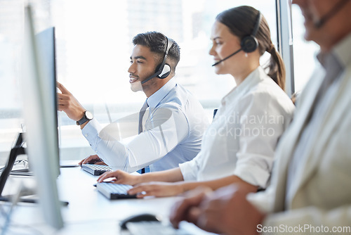 Image of Theyll help you in a matter of minutes. call center agents wearing headsets while sitting at their computers.