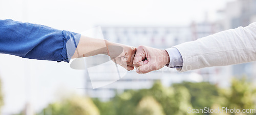 Image of The way a team works determines its success. two unrecognizable business people fist bumping outside.