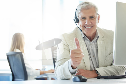 Image of If youre satisfied then Im happy. a mature man showing thumbs up while working in a call center.