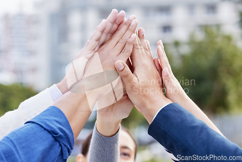 Image of Cooperation is the thorough conviction. a group of unrecognizable businesspeople high fiving while standing outside.