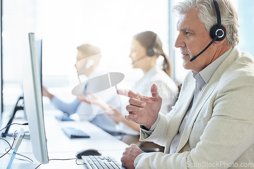 Image of We provide solutions as fast as we answer your call. a mature man wearing a headset while working in a call center.