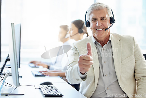 Image of Making sure the customer is always happy. a mature man showing thumbs up while working in a call center.