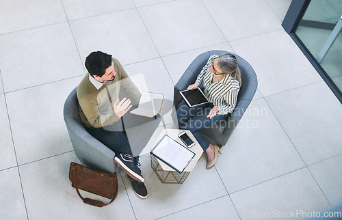 Image of Coming up with solutions that best suit their business. High angle shot of two businesspeople having a discussion in an office.