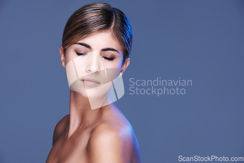 Image of Glowing beauty. A beautiful young woman with her eyes closed isolated on grey.