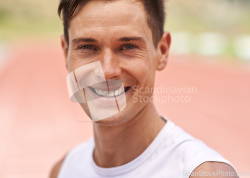 Image of Life is about doing what you love. Portrait of a happy handsome athlete standing on the track.