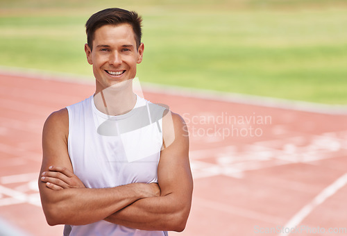 Image of Just happy to be competing. Portrait of a happy handsome athlete standing on the track.