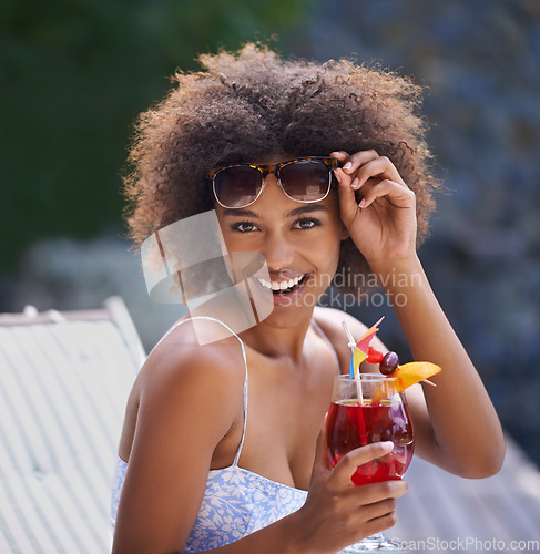 Image of Loving the cocktails and sunshine. Attractive ethnic female posing with sunglasses and fruity cocktail.