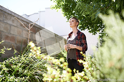 Image of My garden - a place my thoughts love to wander. A cropped shot of a beautful young woman drinking coffee in her garden.