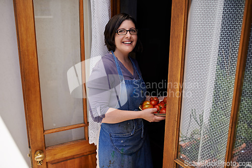 Image of Fresh out my garden, straight to my kitchen. A portrait of a happy middle-aged woman bringing fresh tomatoes in from her garden.