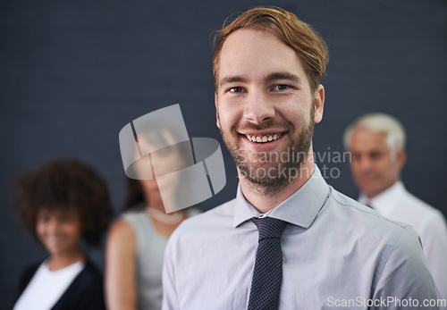 Image of Teamwork divides the task and multiplies success. a young professional man standing in front of a group of coworkers.