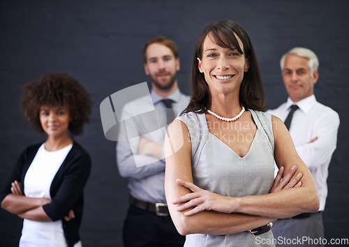 Image of Success comes from solidarity. a professional woman standing in front of a group of coworkers.