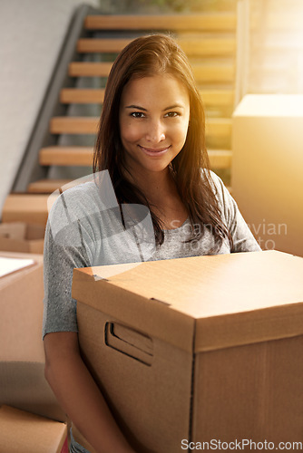 Image of Just gotta unpack these boxes now. Cropped portrait of a young woman moving into her new house.