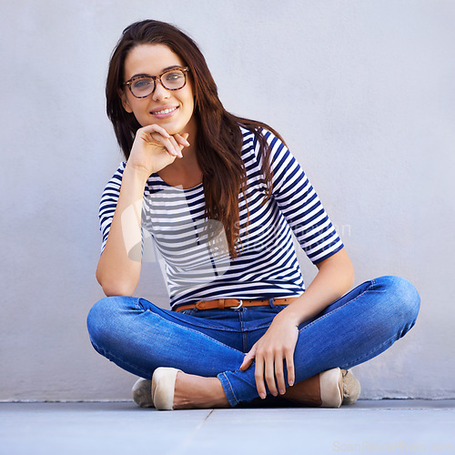 Image of Easygoing confidence. Full-length portrait of a beautiful young woman sitting on the floor.