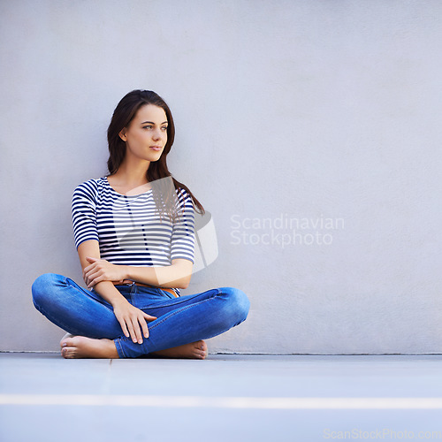 Image of Free to be myself. Full length shot of a beautiful young woman sitting on the floor.