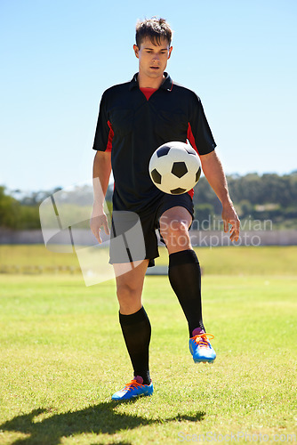 Image of He can keep this ball in the air for hours. a young footballer bouncing a ball on his knee.