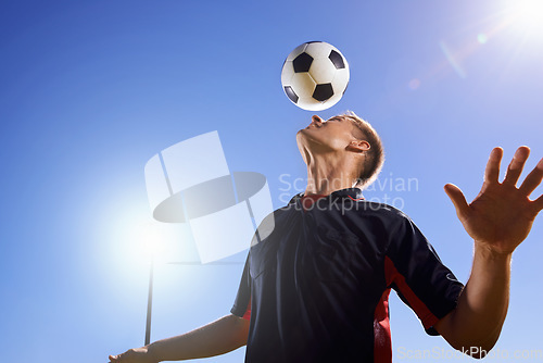 Image of Balance and skill. a young footballer bouncing a ball on his head.