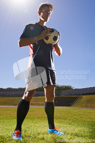 Image of Dedicated to perfection. a young footballer standing on a field with a ball in his hands.