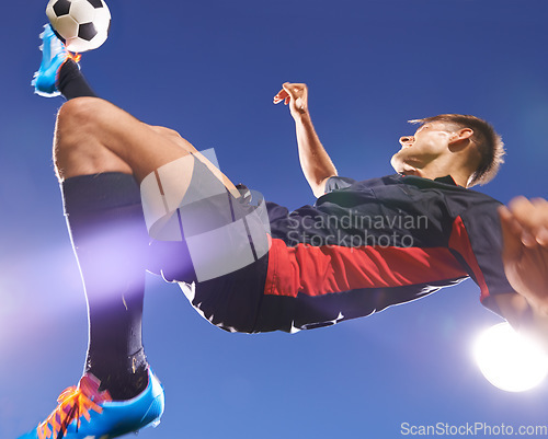 Image of The perfect bicycle kick. a young footballer kicking a ball in mid-air.