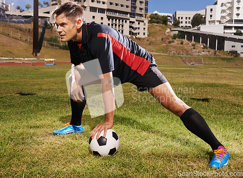 Image of Warming up. a young footballer stretching on the field.