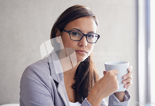 Image of Having a much-needed coffee break. Portrait of an attractive young businesswoman drinking coffee in her office.