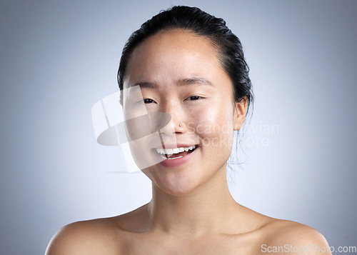 Image of You look better when you smile. a young woman standing against a grey background.