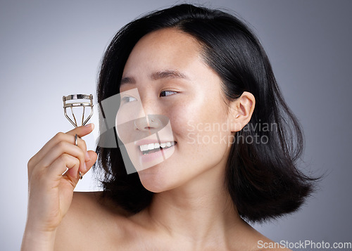 Image of This might be the best thing that Ive come across. a young woman curling her eyelashes against a grey background.