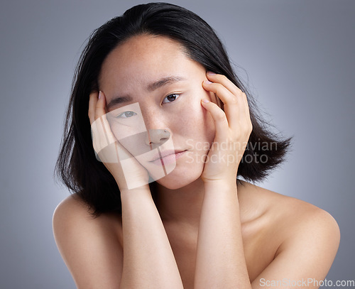 Image of Can you tell how bored I am. a young woman standing against a grey background.