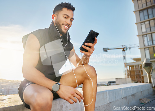 Image of I created this playlist especially for working out. a man wearing earphones while sitting outside in exercise clothes.