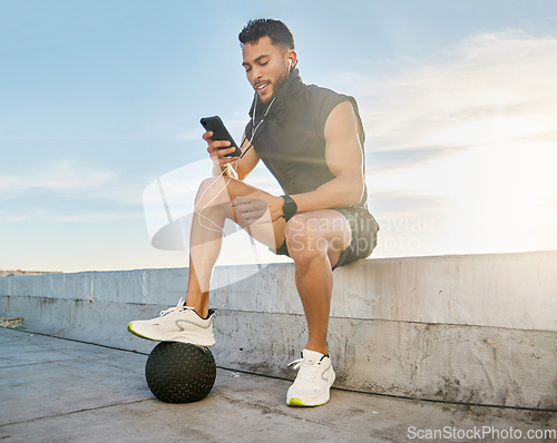 Image of Its my virtual accountability buddy. a man wearing earphones while sitting outside in exercise clothes.