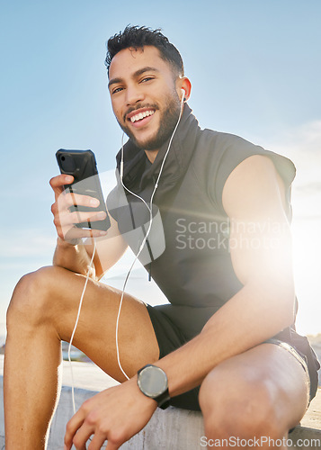 Image of Once I open my music player, the timer starts. a man wearing earphones while sitting outside in exercise clothes.