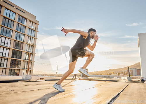 Image of Create good habits and achieve your goals. a sporty young man out on a rooftop for a workout.