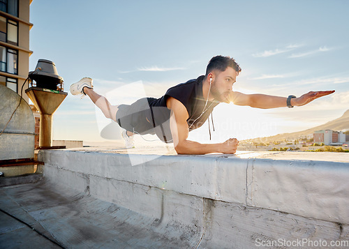 Image of Move outside your comfort zone if you want to achieve greatness. a man doing a single-arm plank while on a rooftop.