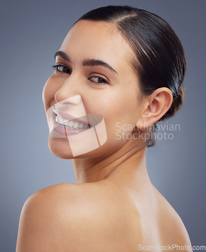 Image of Im glowing, right. Studio shot of a beautiful young woman posing against a grey background.