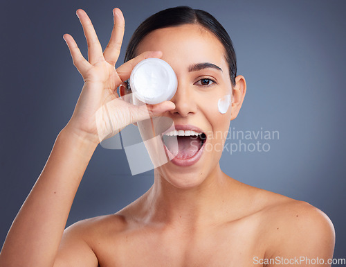 Image of Your skin needs a good moisturiser. Studio shot of a beautiful woman holding up a skincare product.