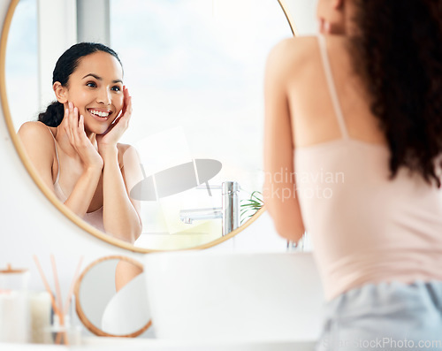 Image of What do you see when you look into the mirror. a young woman admiring her skin in a bathroom at home.