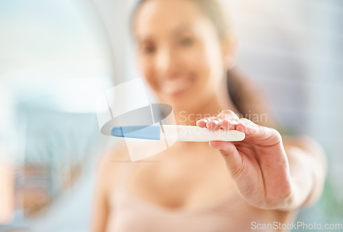 Image of Weve got a result. an unrecognizable woman holding a pregnancy test at home.