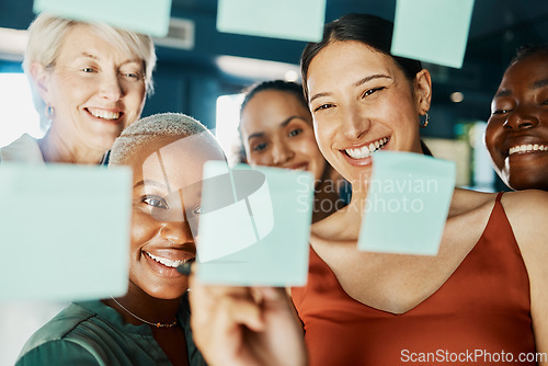 Image of Its fun coming up with a plan for success. an attractive and diverse group of businesswomen working with sticky notes on a glass wipe board in the boardroom.