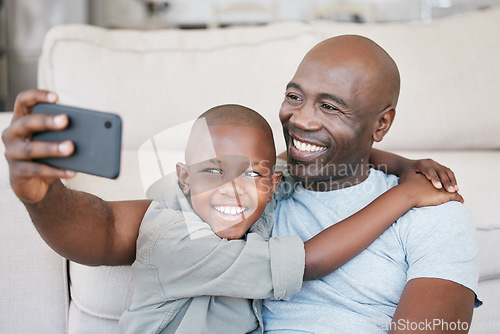 Image of Being part of a family means smiling for photos. a father and son using a cellphone on the sofa at home.