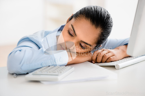 Image of Just a little cat nap. a young businesswoman taking a nap at her desk.