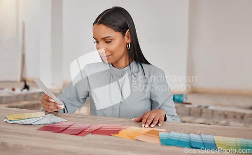 Image of I like all of them. a young woman looking at different colour swatches while renovating her house.