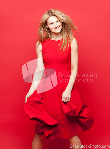 Image of One groovy cool lady. a beautiful young woman dancing against a red studio background.