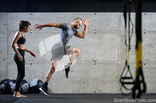 Image of A fit couple in a modern gym, engaging in running exercises and showcasing their athletic prowess with a dynamic start.