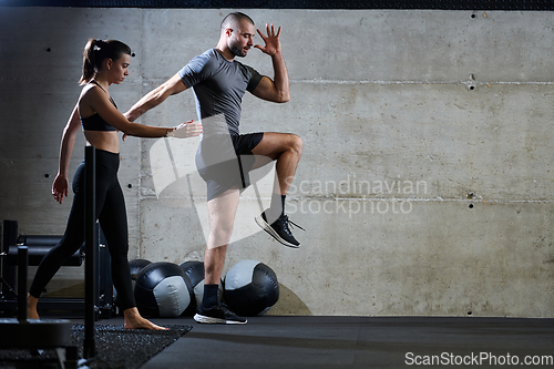 Image of A fit couple in a modern gym, engaging in running exercises and showcasing their athletic prowess with a dynamic start.