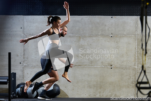 Image of A fit couple exercising various types of jumps in a modern gym, demonstrating their physical fitness, strength, and athletic performance