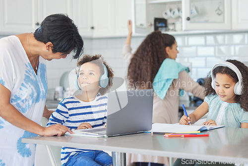 Image of No time for cuddles, sorry gran. a mature woman helping her grandkids with their school work at the kitchen table.