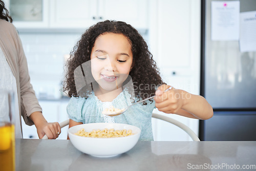 Image of Woke up starving. an adorable little girl having breakfast at the kitchen table.